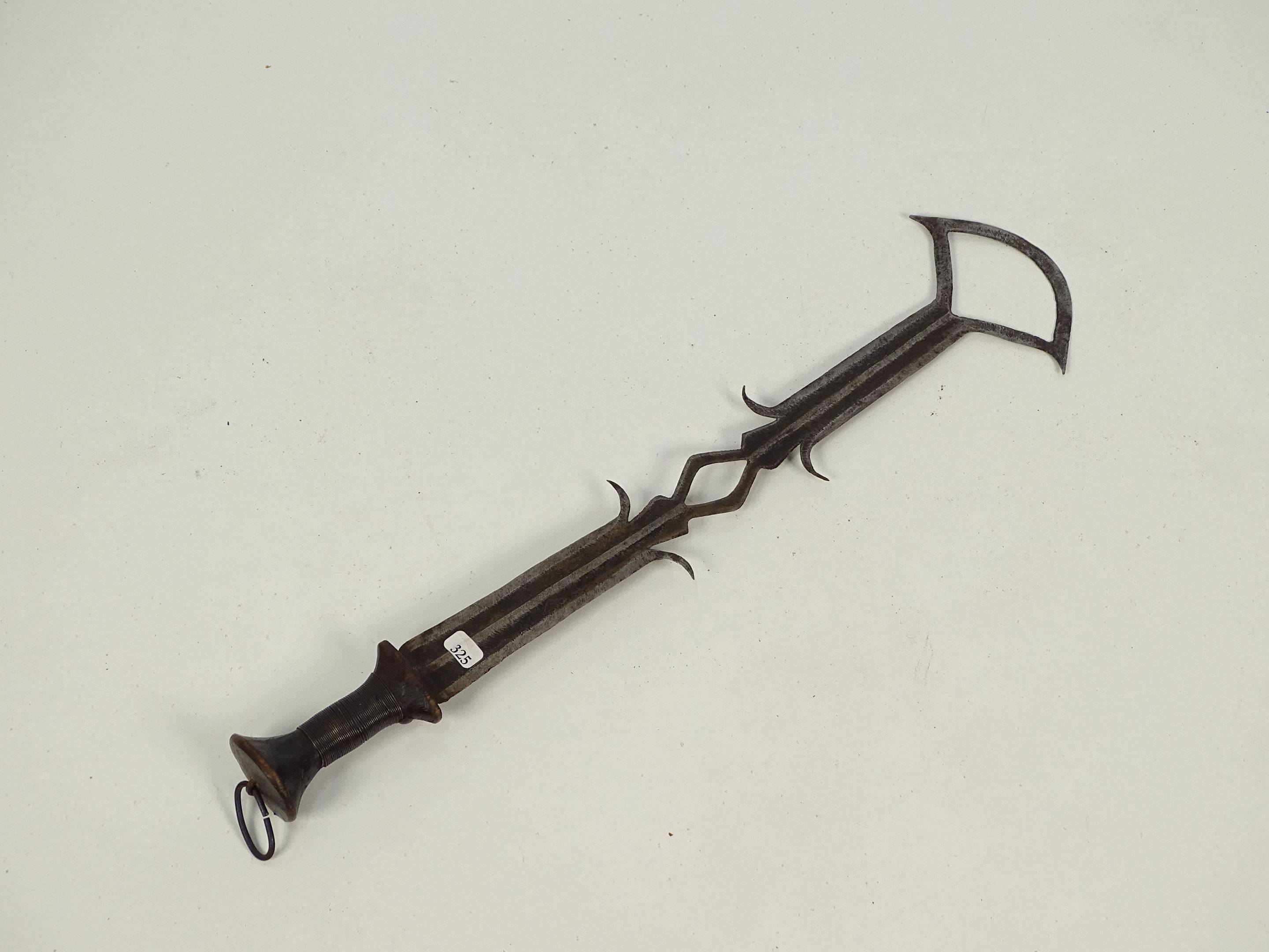 Ancienne épée courte en bois métal et cuivre dont la lame multipointe se...