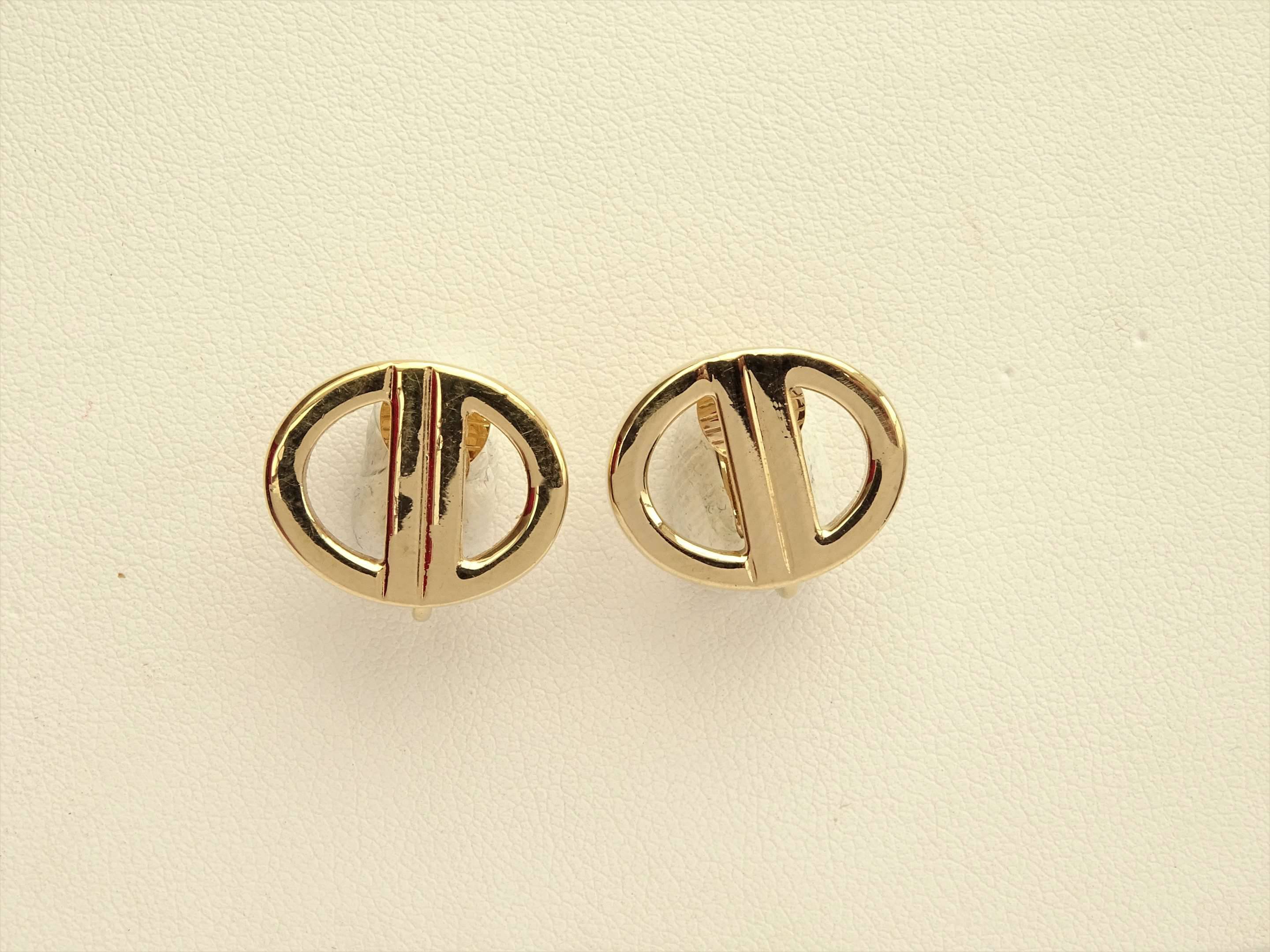CHRISTIAN DIOR Paire de clips d oreilles en metal dore monogrammes. En boite. Tres bel etat. Vente aux encheres Argenterie Orfevrerie Metal argente