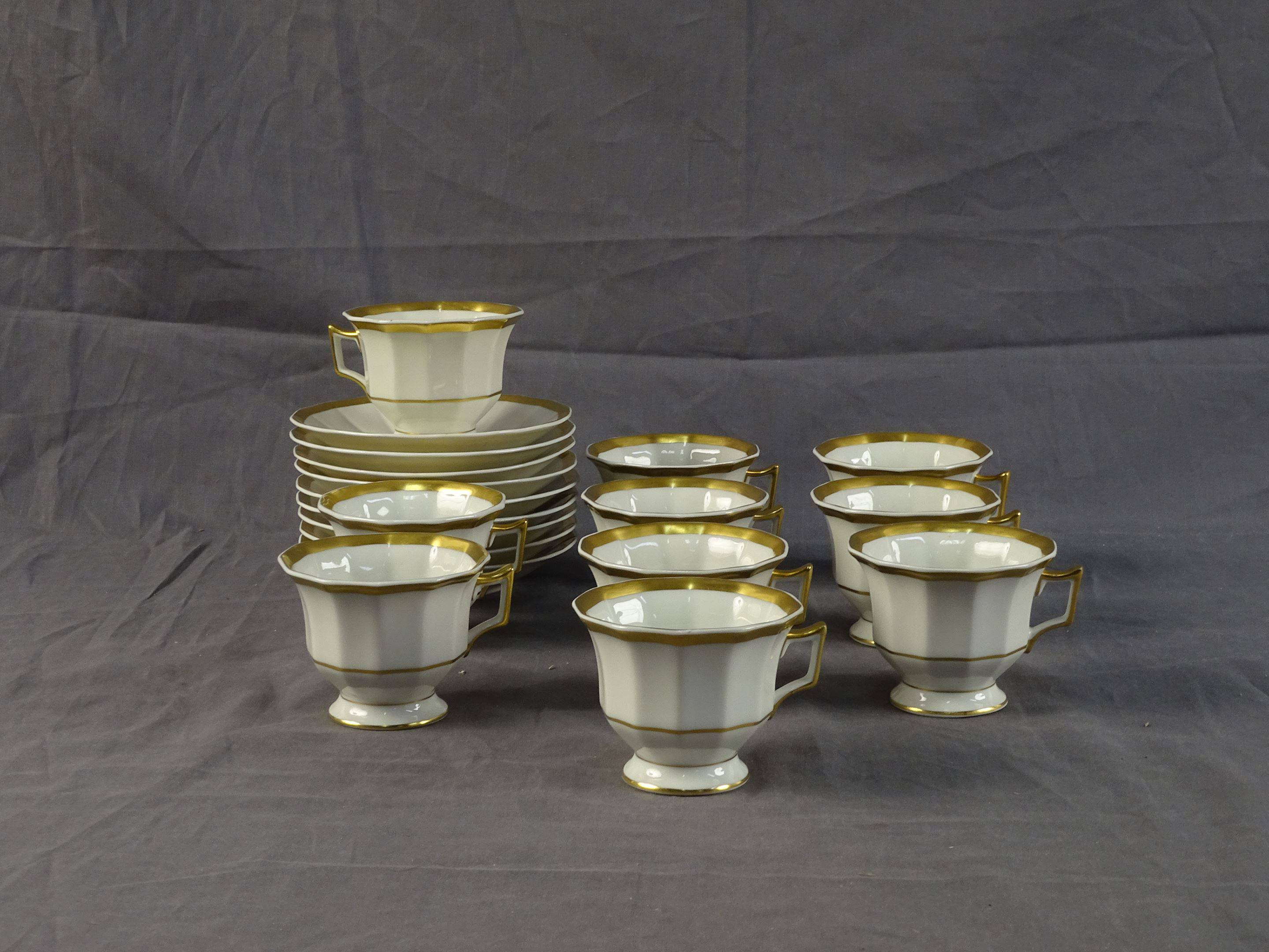 REYNAUD - Dix tasses et neuf sous-tasses en porcelaine crème à liseré or