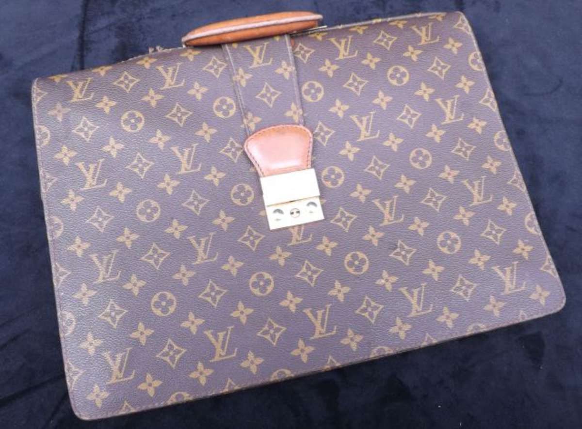 Louis Vuitton. Serviette Ambassadeur en toile enduite monogram et cuir  naturel. Languette et toile décousue,, Vente aux enchères