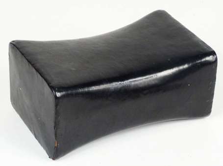 Un appui-nuque en cuir laqué noir. Longueur 20 cm,