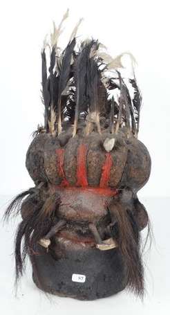 Ancienne tête votive en terre décorée de plumes de