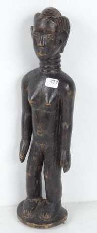 Une ancienne statuette en bois noirci. Hauteur 35 