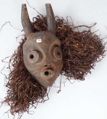 un masque de danse en bois naturel et paille. 