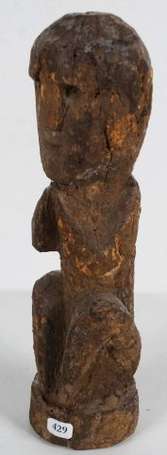 Une petite statue en bois d'un personnage assis en
