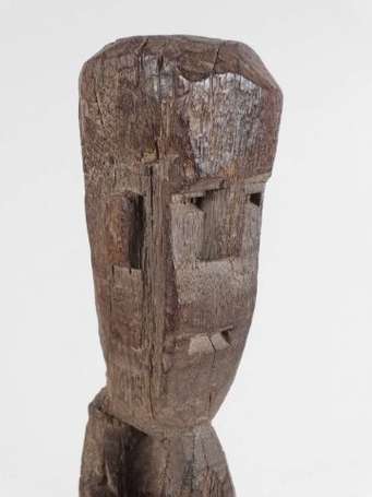 Une statue votive en bois représentant une femme 