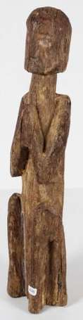 Une statue votive en bois représentant un 