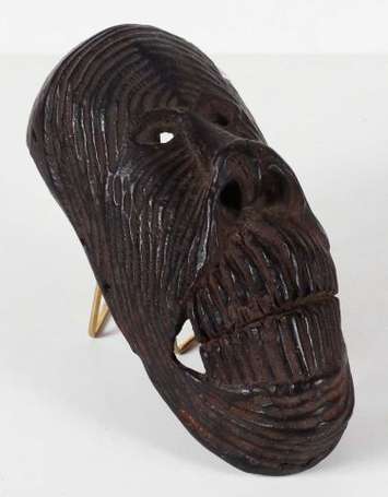 Un ancien masque de singe en bois dont la surface 