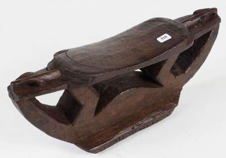 Un ancien appui-nuque en bois dur à patine d'usage