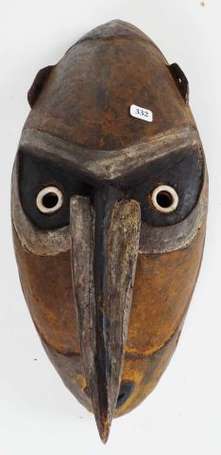 Un ancien masque en bois dur polychrome. 
