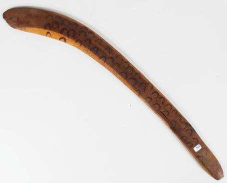 Un ancien boomerang en bois dur décoré au feu. 