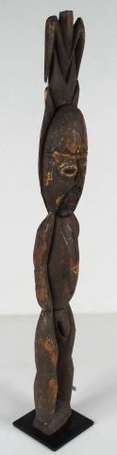 Une statuette rituelle masculine en bois coiffée 