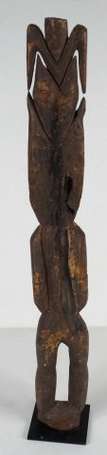 Une statuette rituelle masculine en bois coiffée 