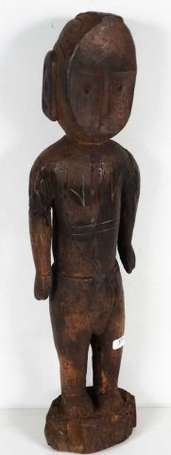 Une ancienne statuette votive en bois dur brun. 