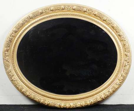 Important miroir ovale en bois doré et sculpté de 
