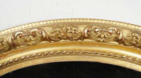 Important miroir ovale en bois doré et sculpté de 