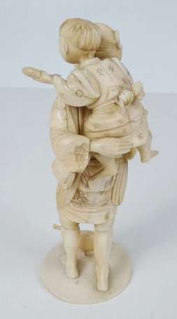 Homme portant un enfant Sujet en ivoire. Japon, 