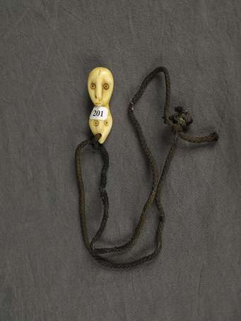Ancien pendentif en ivoire représentant une tête 