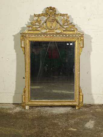 Miroir en bois doré, le le fronton à décor sculpté