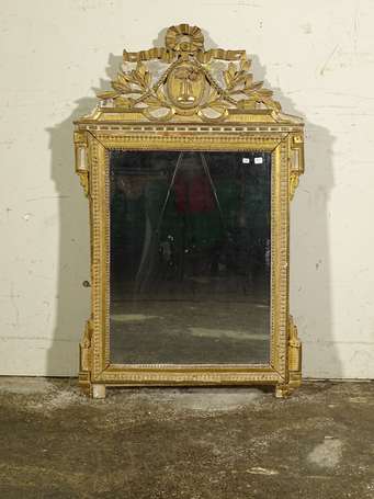 Miroir en bois doré, le le fronton à décor sculpté