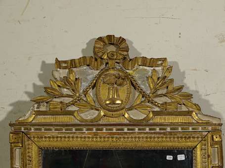 Miroir en bois doré, le le fronton à décor sculpté