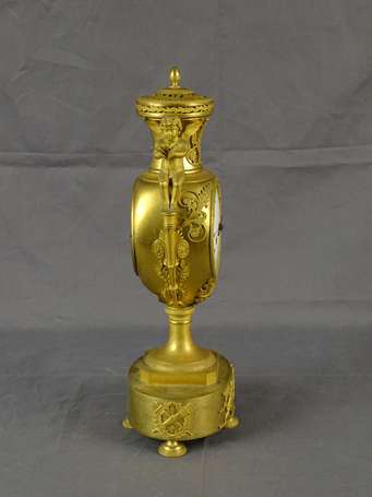 Pendule urne en bronze ciselé et doré, Au dessus 