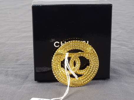 CHANEL - Broche ronde en métal doré, décor au 