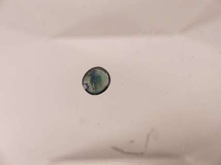 Saphir rond bleu-vert sur papier. 5,4 x 4,9 x 3,2 